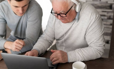 Εικόνα που δείχνει ενα ηλικιωμένο άτομο με αναπηρία να αποκτά ψηφιακές δεξιότητες.