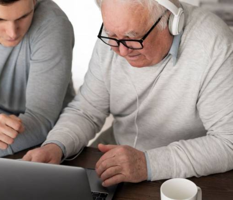 Εικόνα που δείχνει ενα ηλικιωμένο άτομο με αναπηρία να αποκτά ψηφιακές δεξιότητες.
